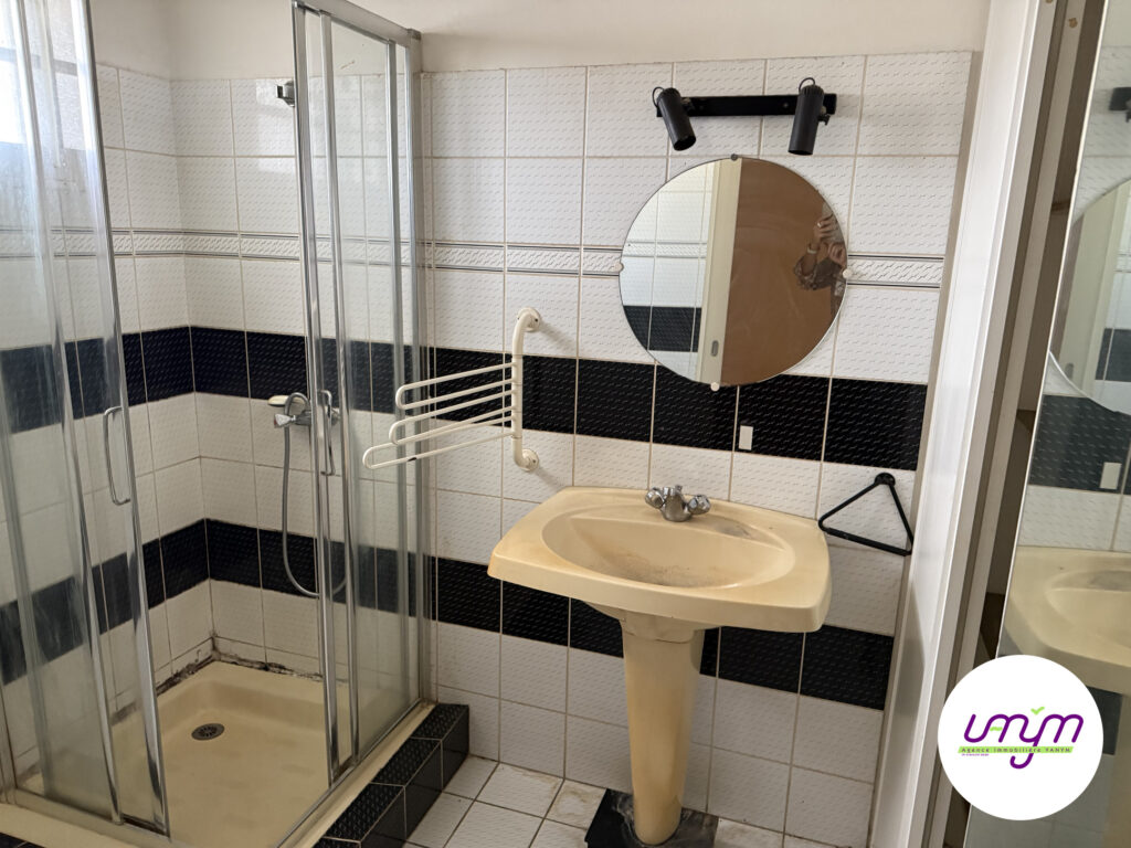 Salle d’eau avec cabine de douche et vasque colonne de la maison F4 à vendre à Koutio, agence Vanym